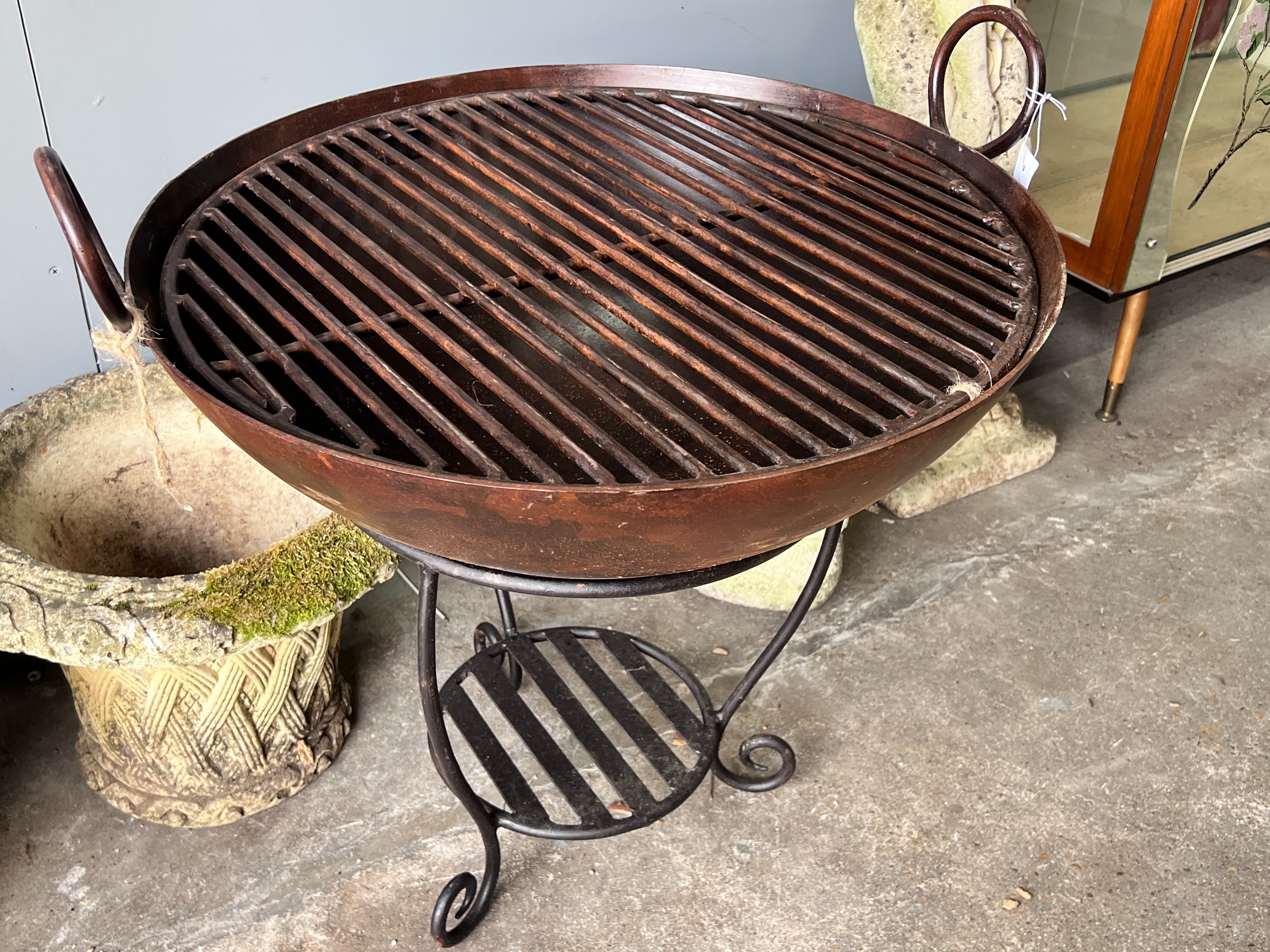 A circular wrought iron fire pit on stand, diameter 61cm, height 66cm